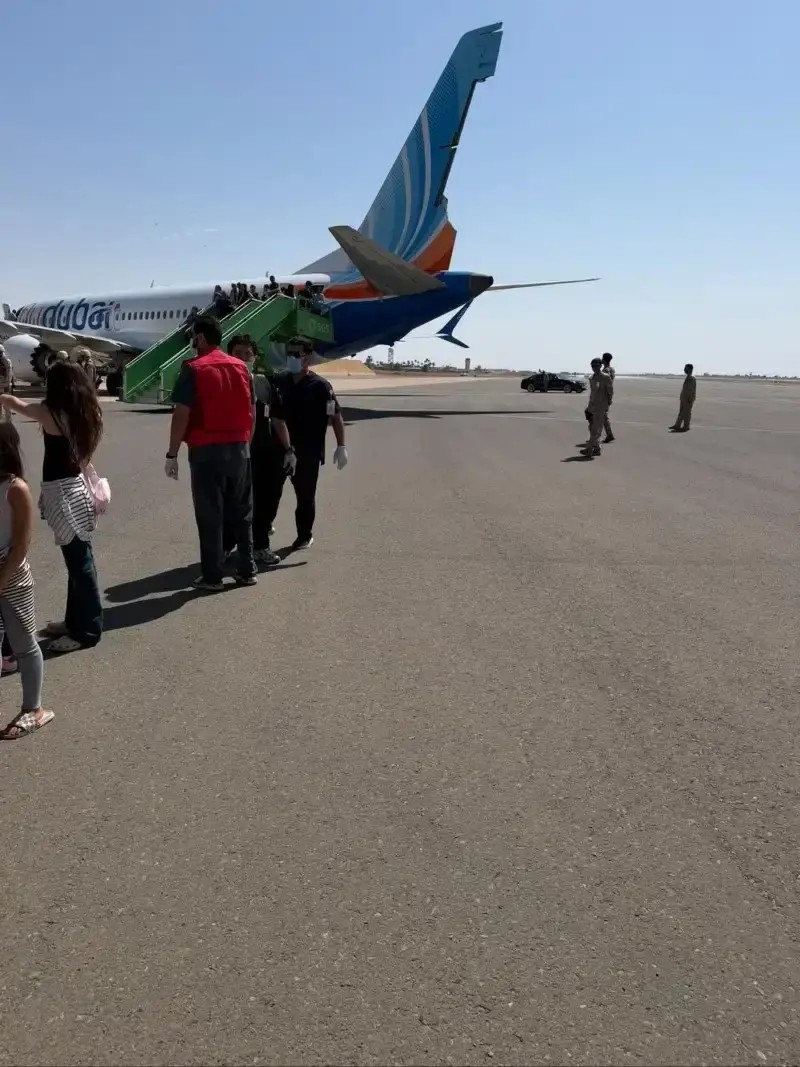 The diverted flydubai aircraft on the tarmac at Tabuk, with passengers and Saudi personnel nearby